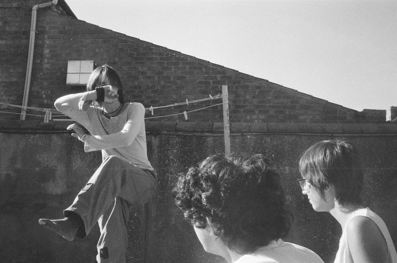 Black and white photograph of a person posing on a rooftop